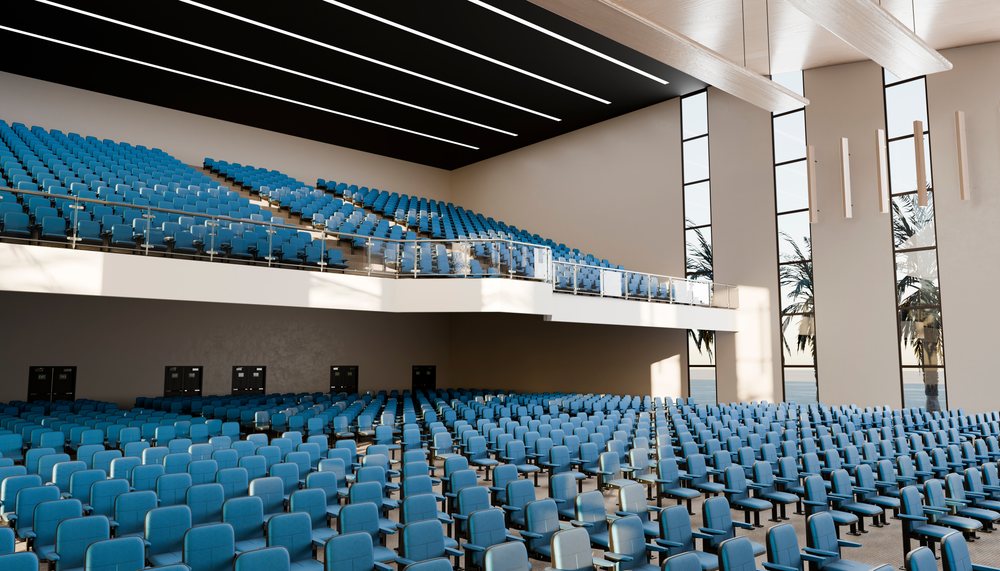 Large modern lecture hall with blue seats and balcony.