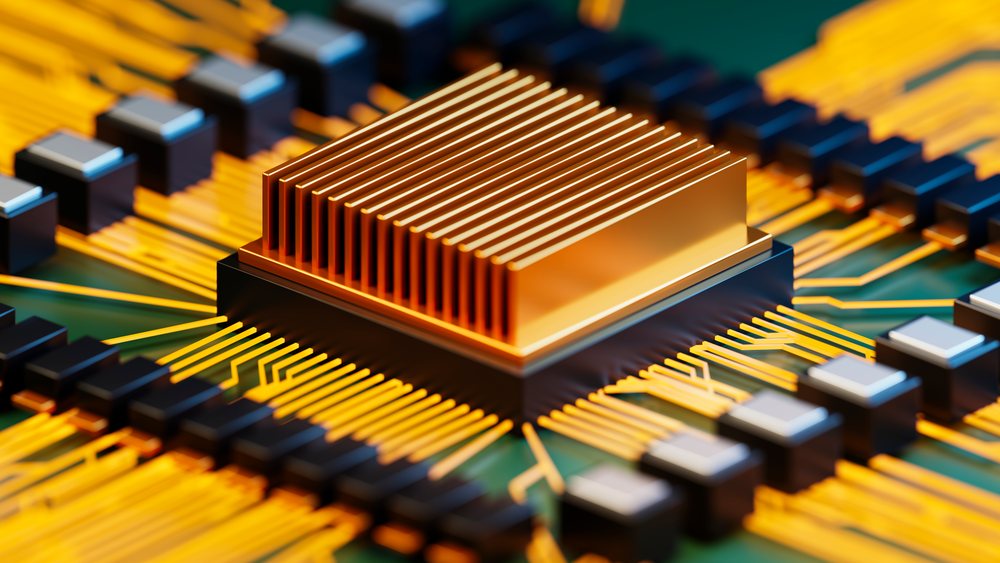 Close-up showing a computer chip with a golden heat sink mounted on a circuit board with electronic components and electrical connections.