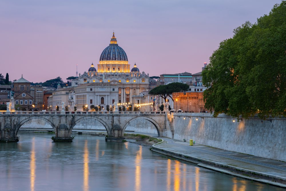 St Peter's Basilica illuminated at Dusk overlooking the river and bridge, Rome, Lazio, Italy.