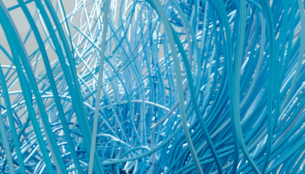 Close-up view of tangled blue network and electric wires representing technology and communication concepts.