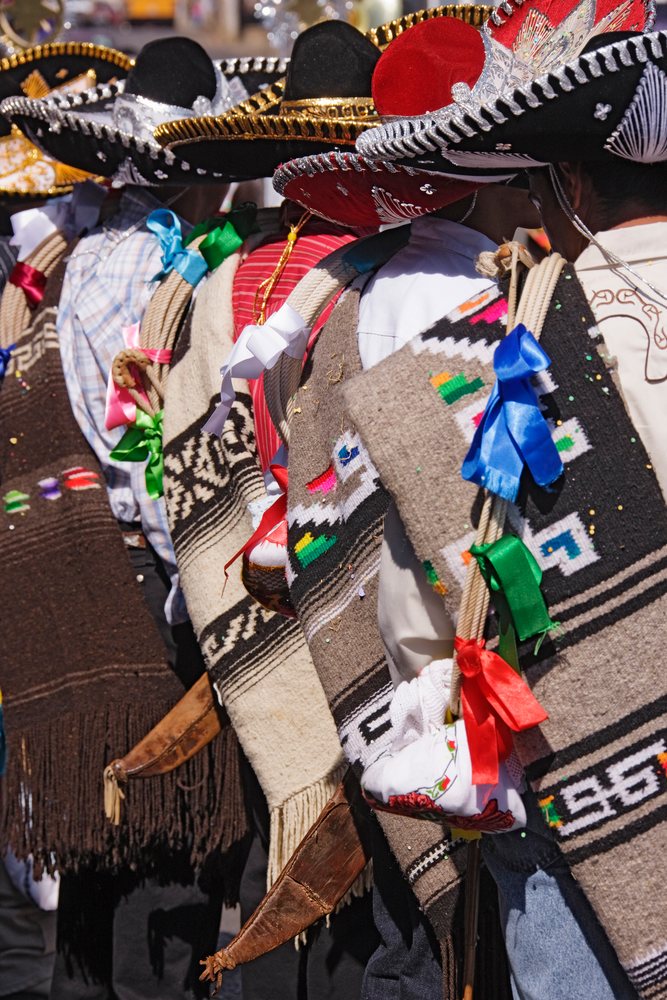 Purepecha men wearing sombrero hats, woven shawls, and colorful ribbons at El Levantamiento del Niño Dios festival in Sevina, Michoacan, Mexico.