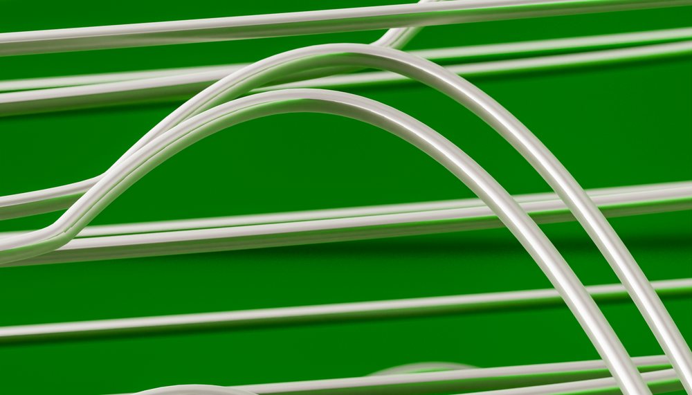 Close-up showing detailed curved white electric guitar strings with visible string reflections against a green background.