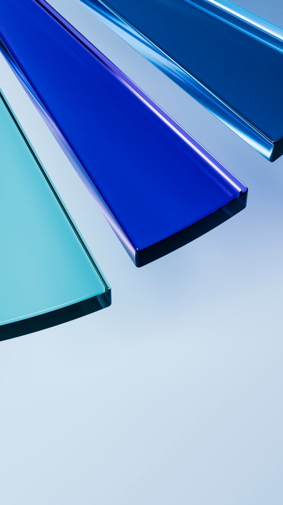 Three colored glass panels in blue and light blue tones arranged on a clean white surface in a minimalist composition.