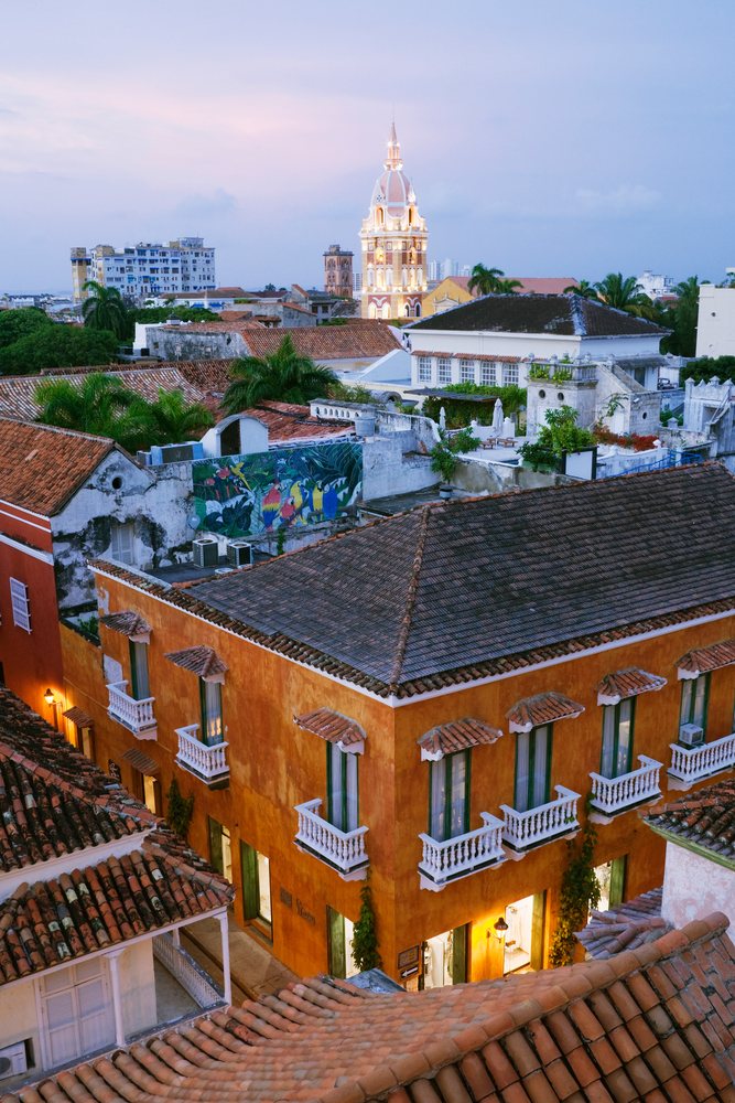 Historic Cartagena Cathedral tower and tiled rooftops illuminated at sunset, Colombia.