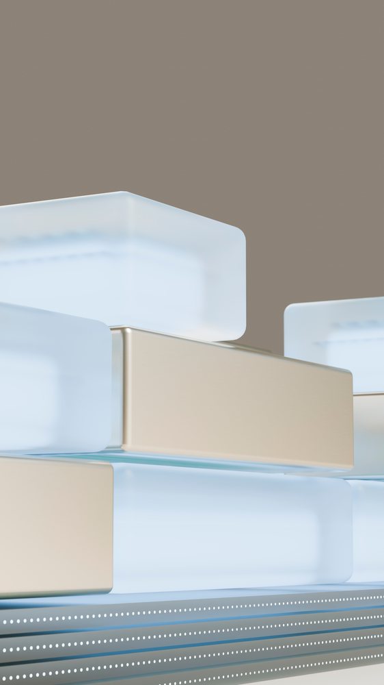 Stacked rectangular metallic and frosted glass blocks form a modern abstract geometric composition on a neutral background.