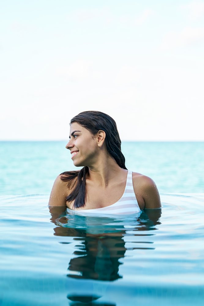 A white woman enjoys swimming