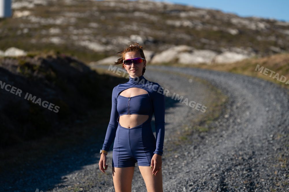 A white woman stands outdoors on a gravel trail in Galicia, Spain