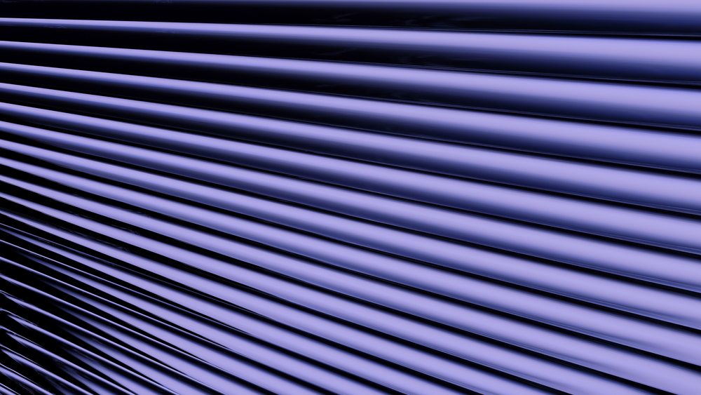 abstract render of smooth blue lines casting shadows in a repetitive linear pattern.