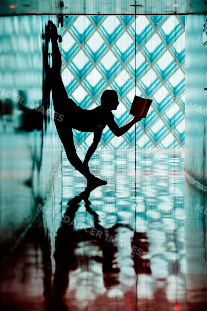 Person reading a book in a yoga pose inside the Seattle public library