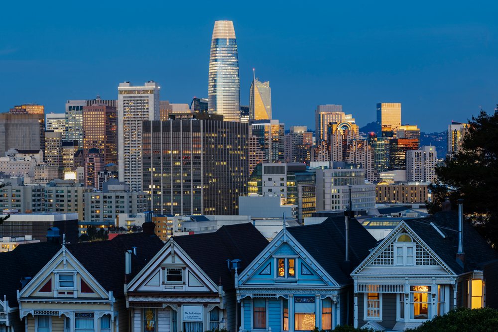 Victorian Painted Ladies houses stand in front of San Francisco's urban skyline at dusk from Steiner Street, Alamo Square, City, Cityscapes, City Life, California, USA.