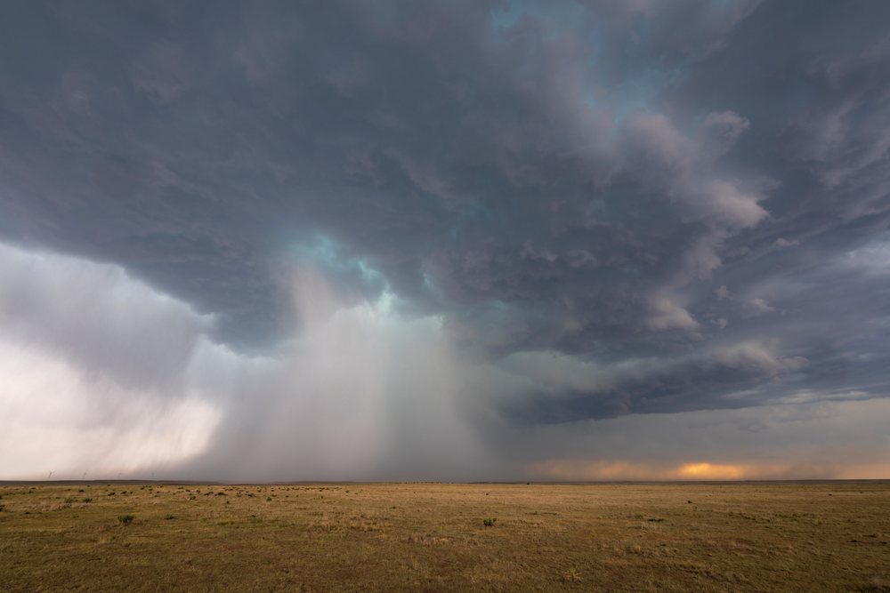 Storm clouds unleashing heavy rain over a dry flat grassland prairie, USA under a turbulent sky, Storm Chasing, Weather, Environment, Tribune, Kansas.