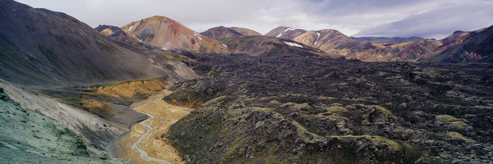 Volcanic lava fields and mountains in rugged natural landscape.