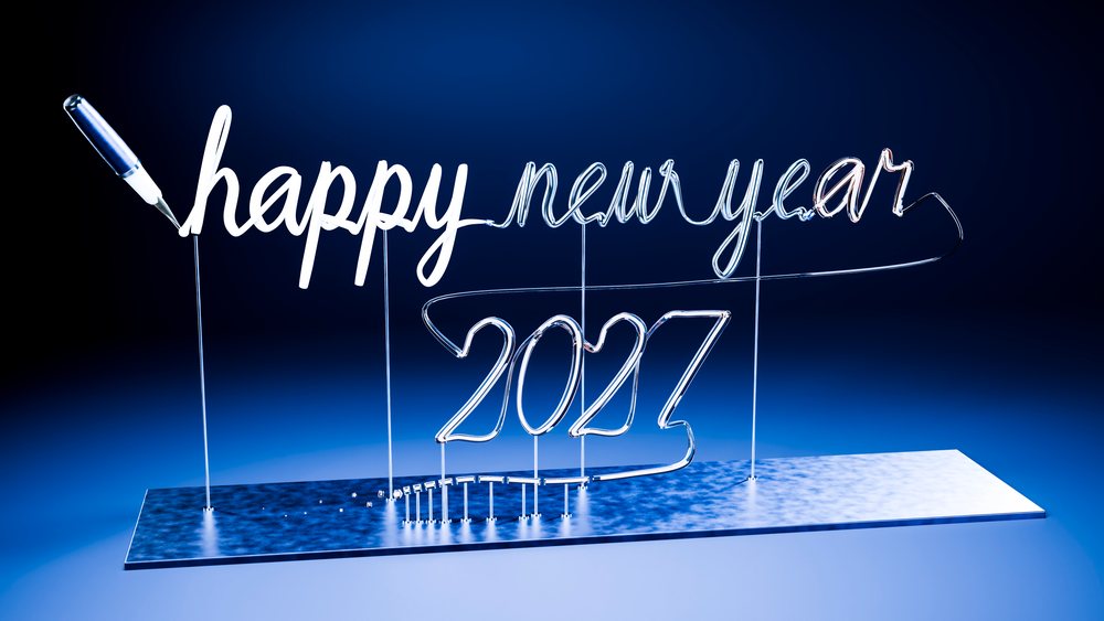 Neon light sculpture spelling happy new year 2027 in cursive script on a base against a blue gradient background.