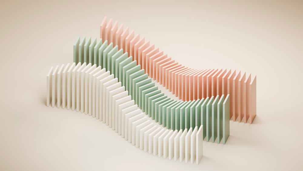 Three curved rows of pastel-colored dominoes arranged and falling on a beige background in a minimalist studio setting.