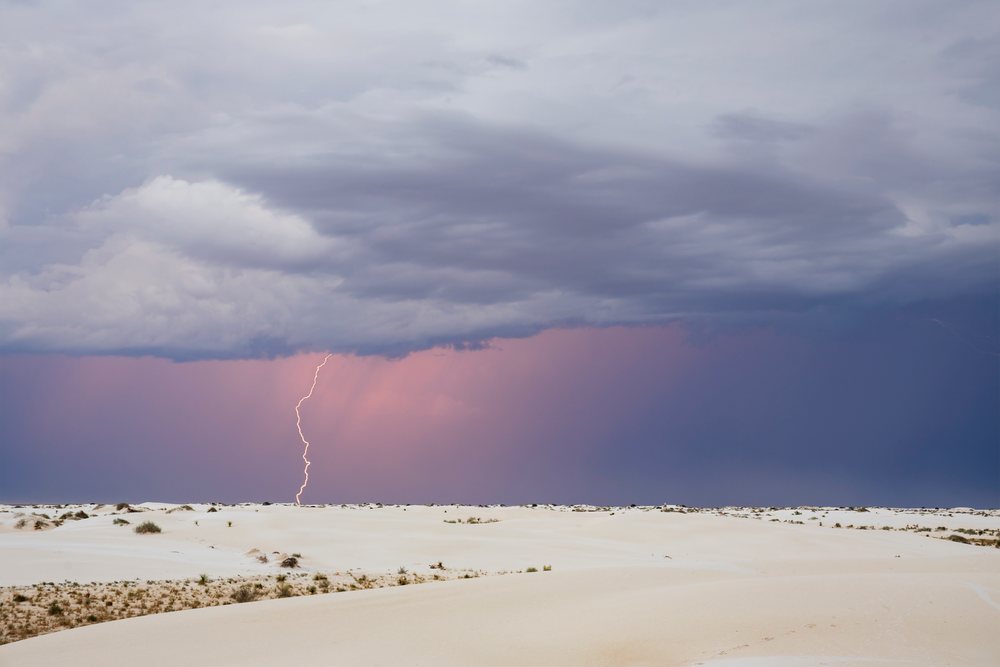 Lightning strikes above white sand dunes under stormy clouds at white Sands National Park, Landscape, Wildlife, Alamogordo, New Mexico, USA.