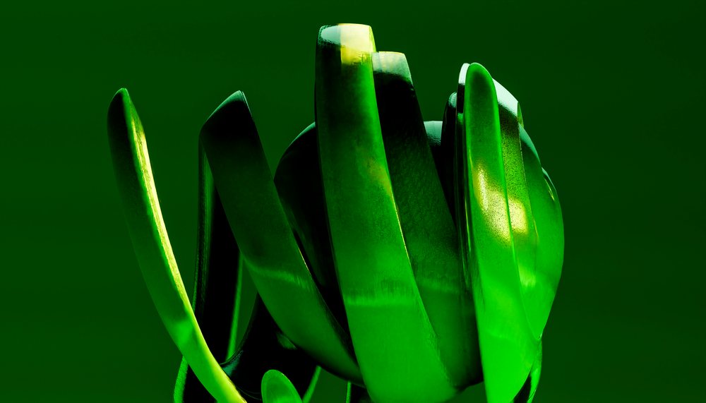 Abstract green sculpture with curved shapes and reflective surfaces against a green background.
