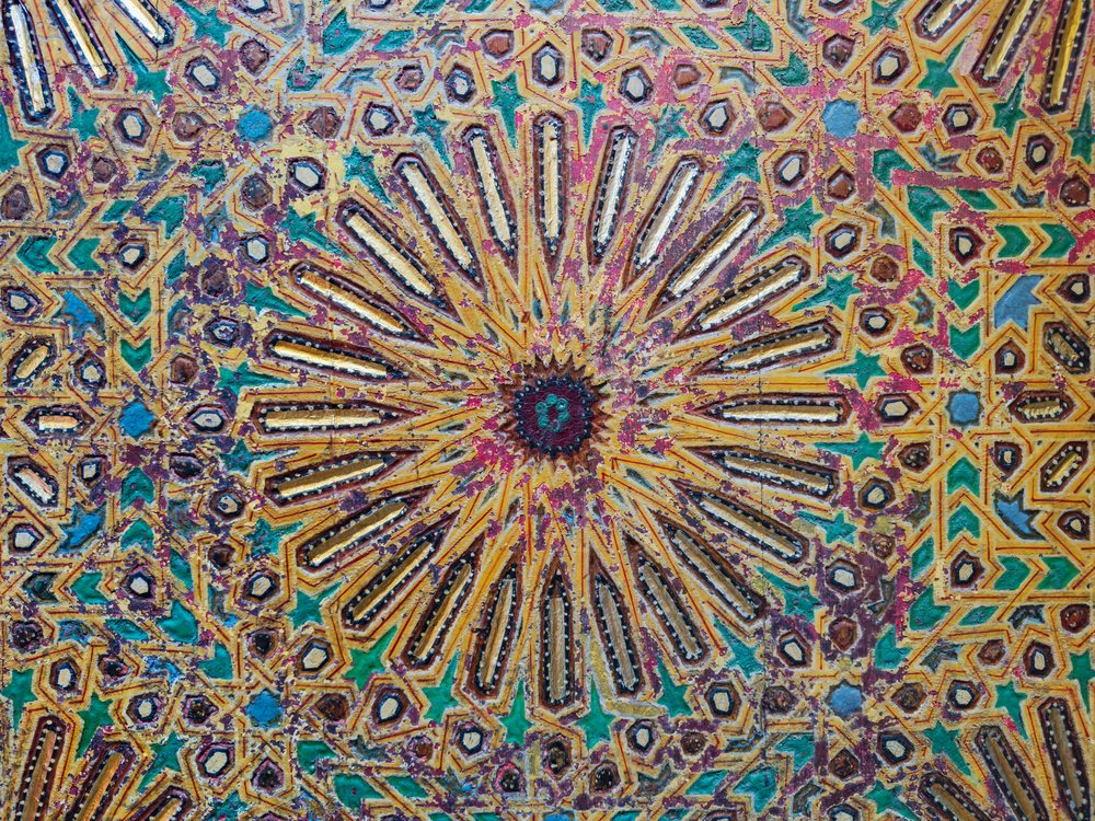 Intricate colorful geometric patterns with star and hexagonal shapes carved on a Door at the Mausoleum of Moulay Idriss II, Landscape, Lifestyle, Fes, Fecs-Meknes Administrative Depar, Morocco.