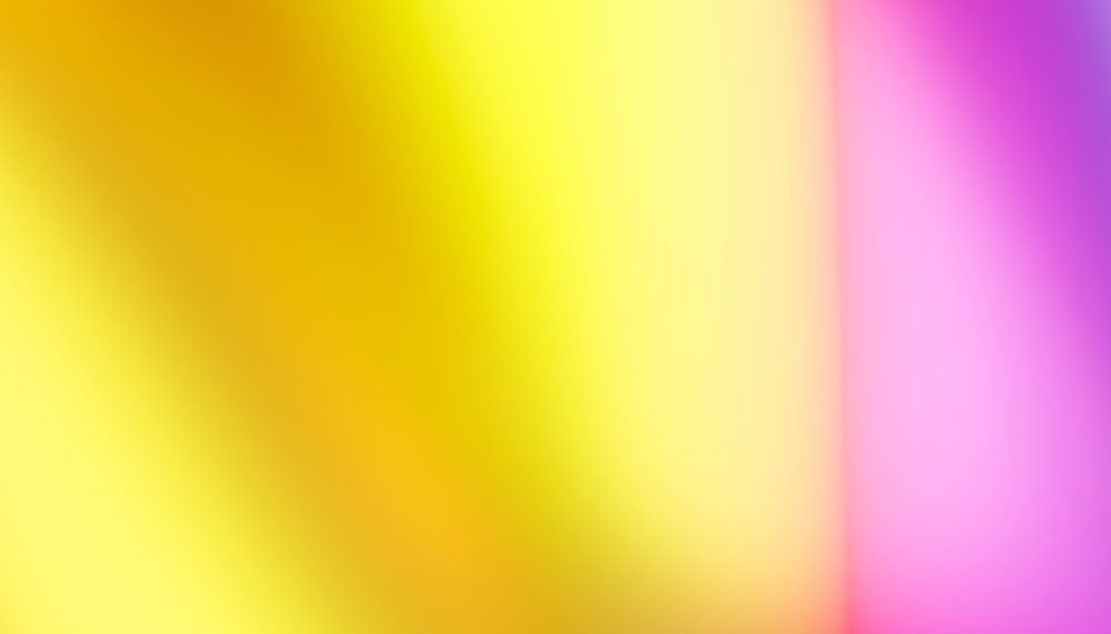 Blurred abstract gradient background featuring smoothly blended yellow, orange, pink, and purple colors.