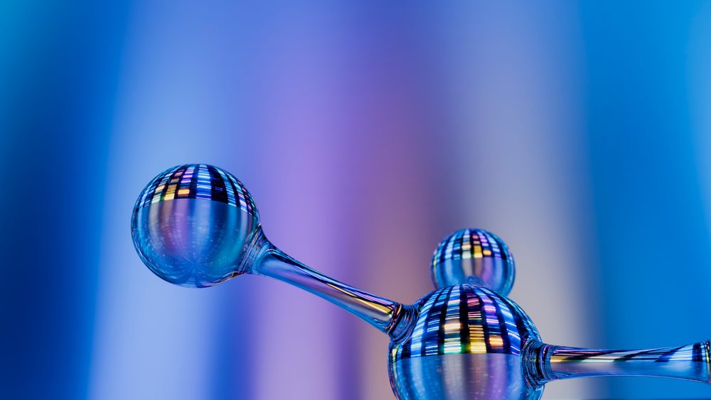 Molecular structure glass model with colorful reflections on blue background.