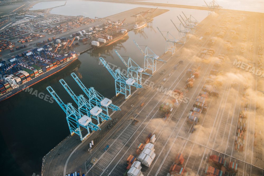 Aerial view of shipping cranes and cargo containers at a port in Long