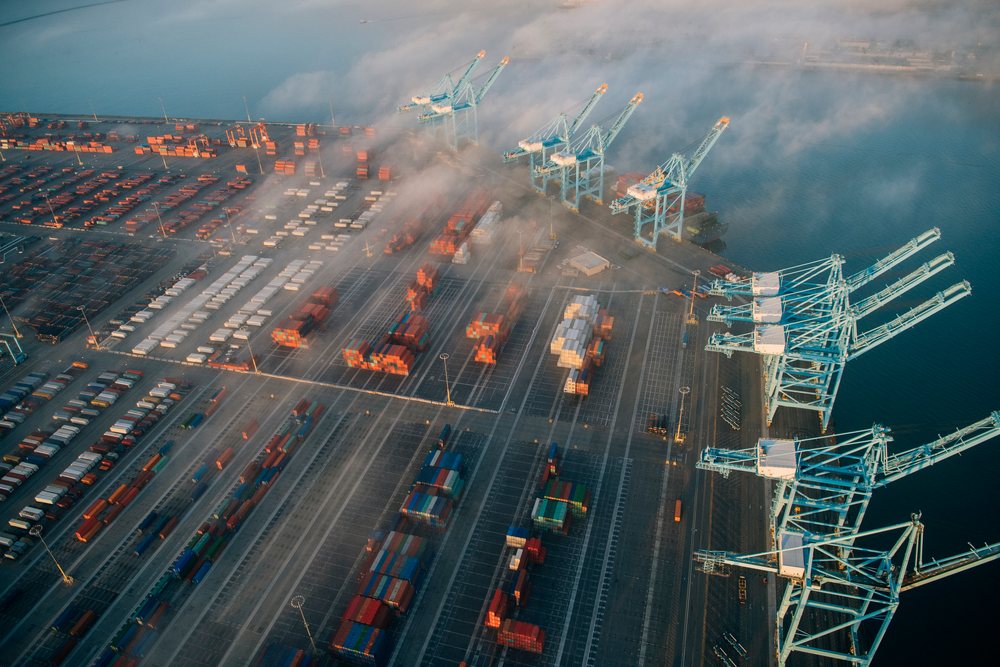 Aerial view of a container terminal with cargo cranes and shipping containers at a major seaport in Long Beach, lifornia, with morning fog present, major seaport in Long Beach, CA, USA.