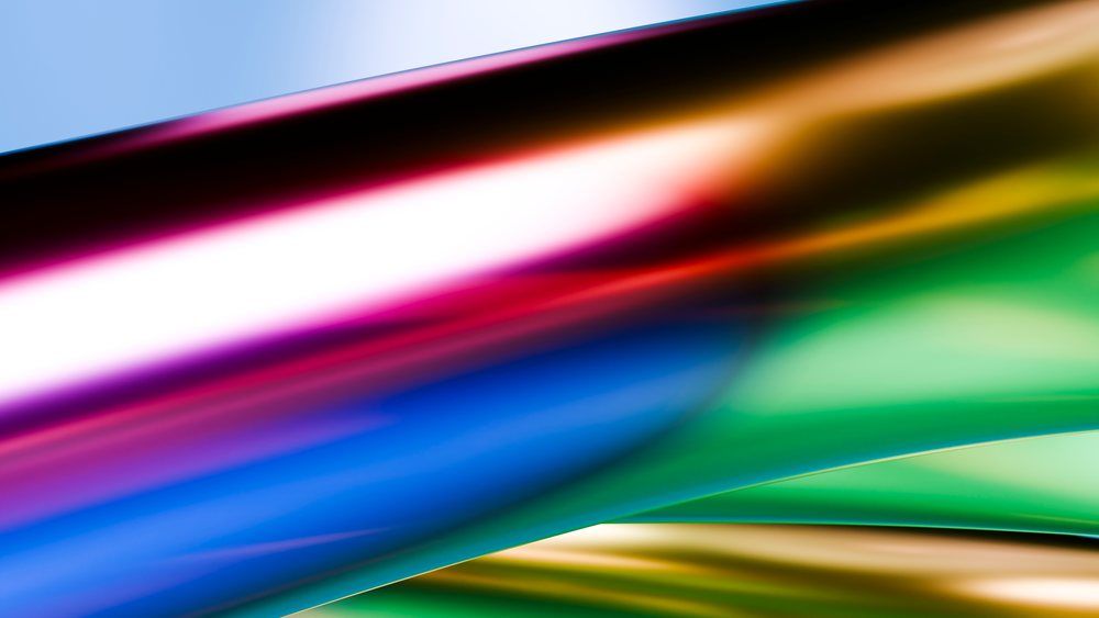 Colorful abstract glass waves with reflective surfaces in vibrant hues of blue, green, and gold.
