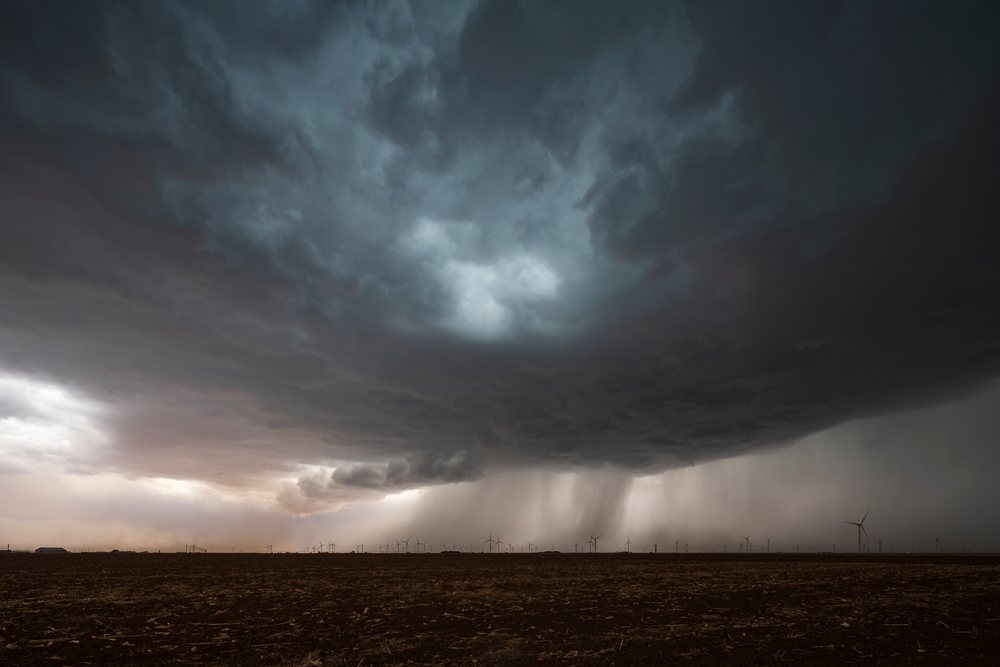 Storm Cell with a Roll Cloud and rain is visible over wind turbines in the Great Plains, Storm Chasing, Weather, Environment, Floydada, Texas, USA.