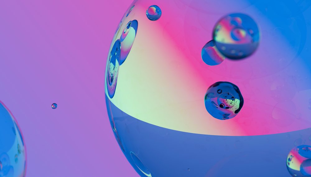 Macro close-up shows colorful oil droplets and bubbles with iridescent reflections on a smooth liquid surface.