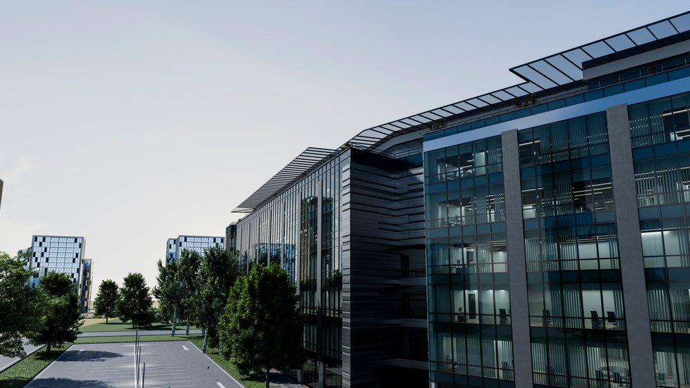 Glass-facade modern office buildings reflect the urban environment with trees and a parking lot nearby during daytime.