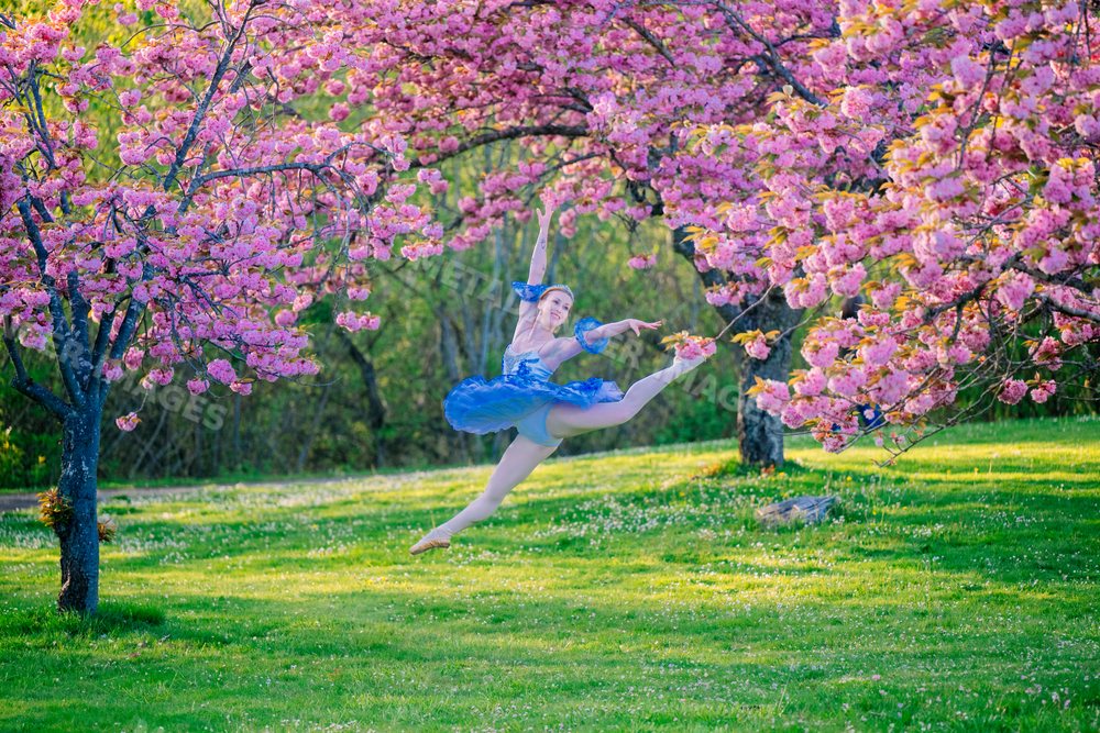 A ballerina leaps gracefully outdoors
