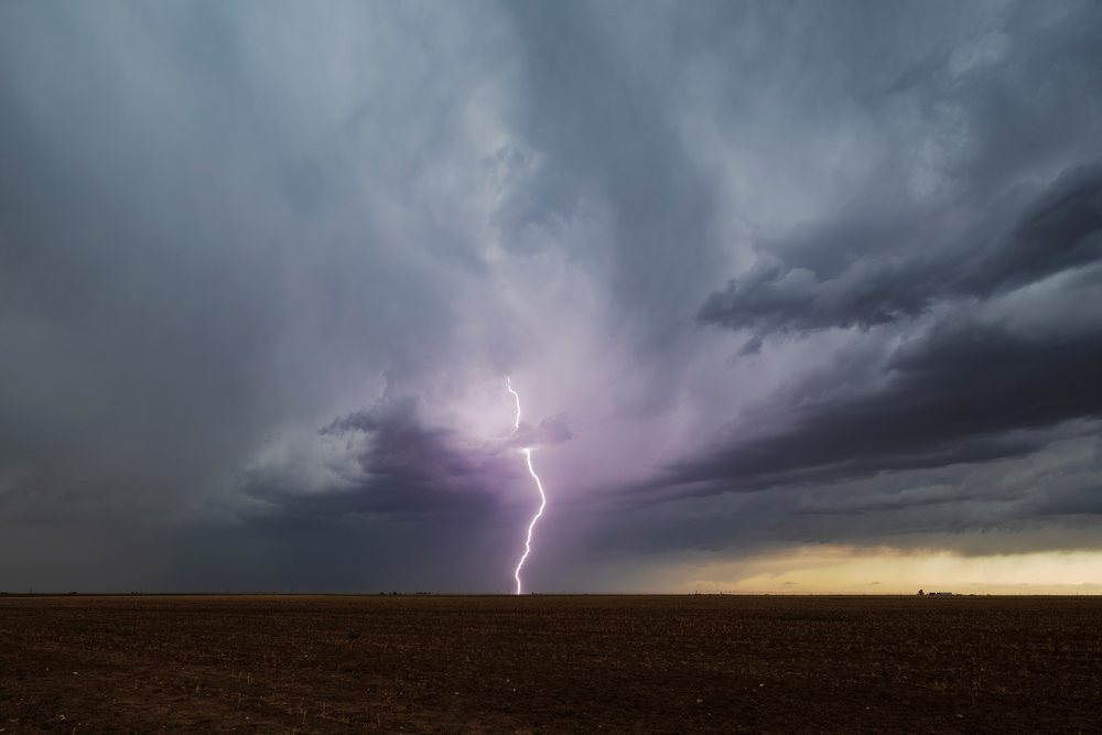 Lightning bolt strikes over flat plains beneath dark storm clouds, Storm Chasing, Weather, Environment, Floydada, Texas, USA.