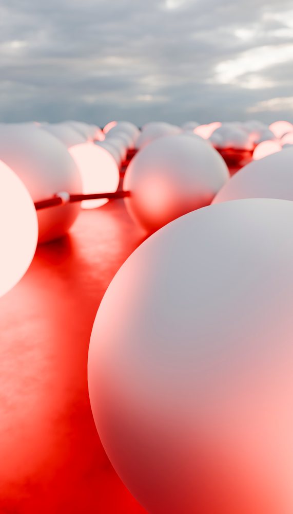 Close-up of white spheres connected and illuminated with red light in an abstract artistic arrangement.