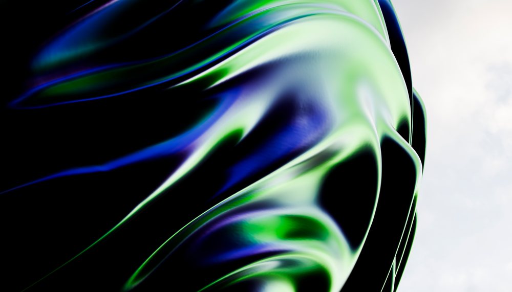 Close-up view of a modern abstract metal sculpture featuring smooth reflective surfaces with green and blue flowing curves.