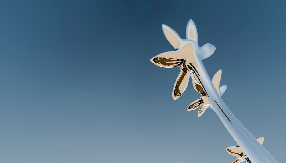 Abstract shiny metal sculptures stand tall against a clear blue sky