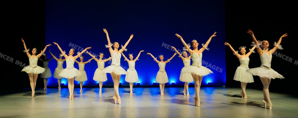 Ballerinas perform a synchronized holiday-themed ballet dance on stage