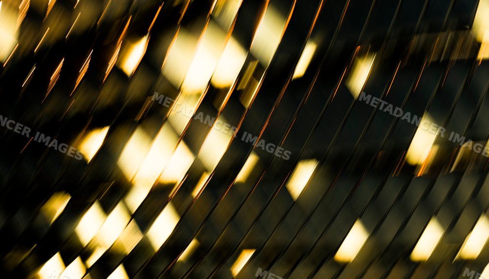 Abstract reflective metal surface with golden light and diagonal