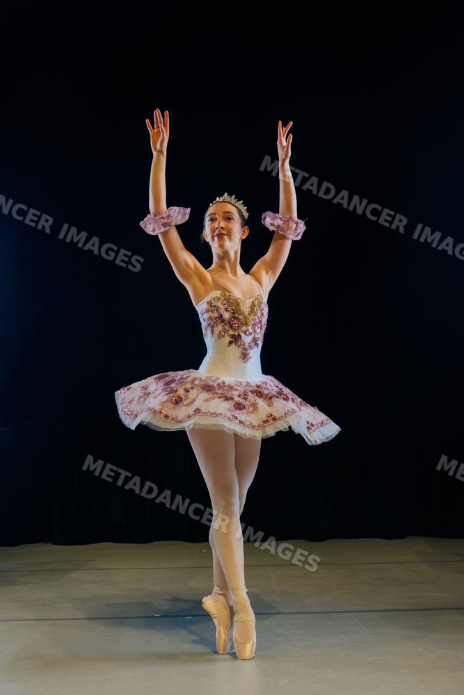 A ballerina performs a classical ballet pose during a stage production