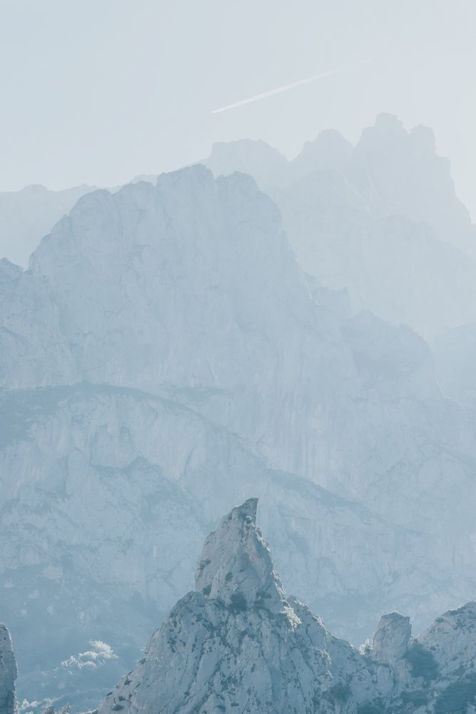 Rocky mountain peak with rugged cliffs and rock formations under a pale sky in a Spain landscape, mountaineering, climbing, landscape.