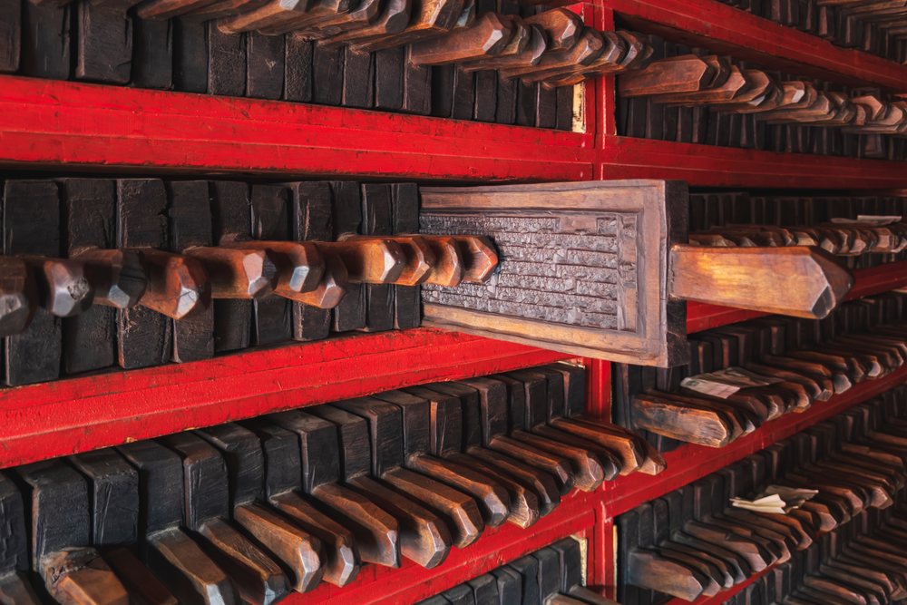 Wooden Tibetan Printing Blocks with carved text are arranged on red wooden shelves at Dege Printing Monastery, China, Sichuan Province, People's Republic of China.