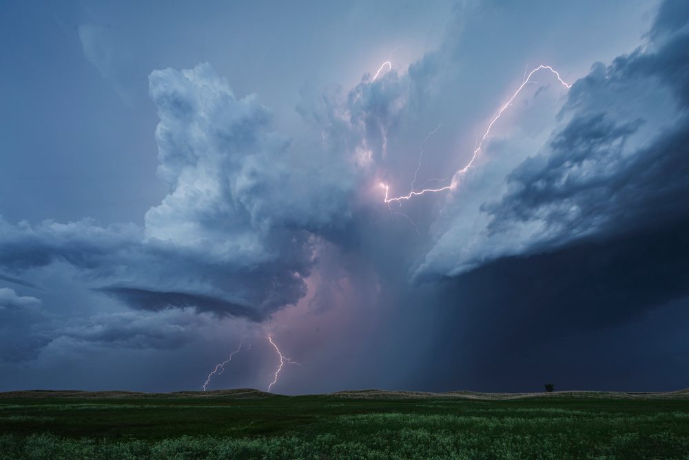 Lightning Strike illuminates storm clouds over Nebraska Sandhills grassland during blue hour, Storm Chasing, Weather, Environmental Issues, Dunning, USA.