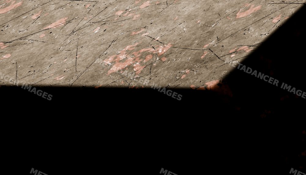 Worn concrete floor with paint spots and shadow
