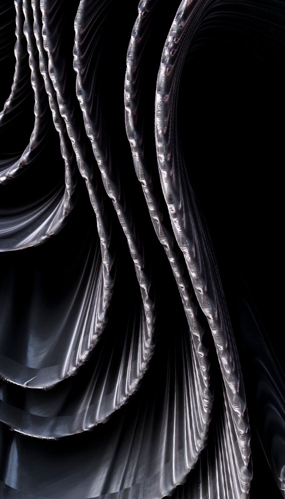Close-up showing shiny metal chains with connected loops and visible links against a black background.