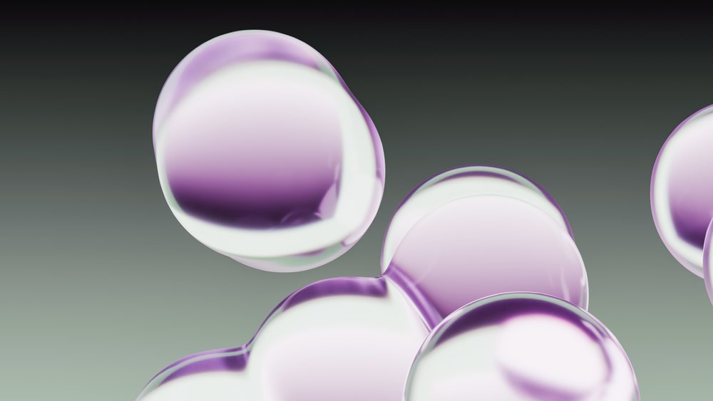 Abstract render of transparent and purple glossy bubbles floating against a gradient background.