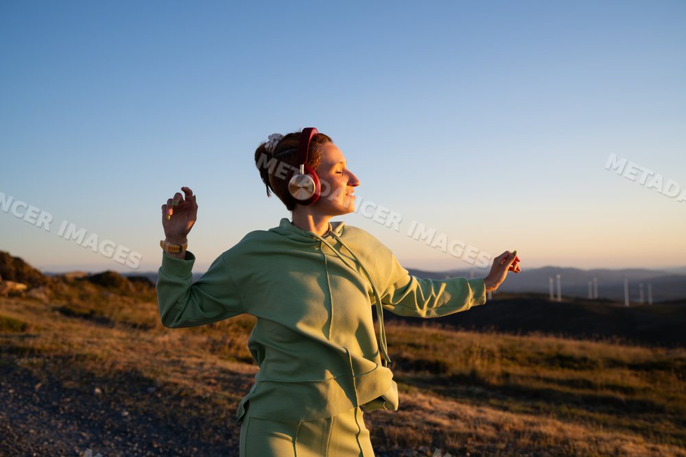 White Woman enjoying music and dancing outdoors at sunset in Galicia