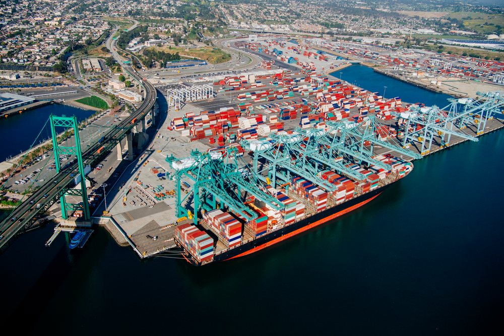 Container ship loaded with cargo containers moored at port terminal with shipping cranes, Port of Long Beach, CA, USA.