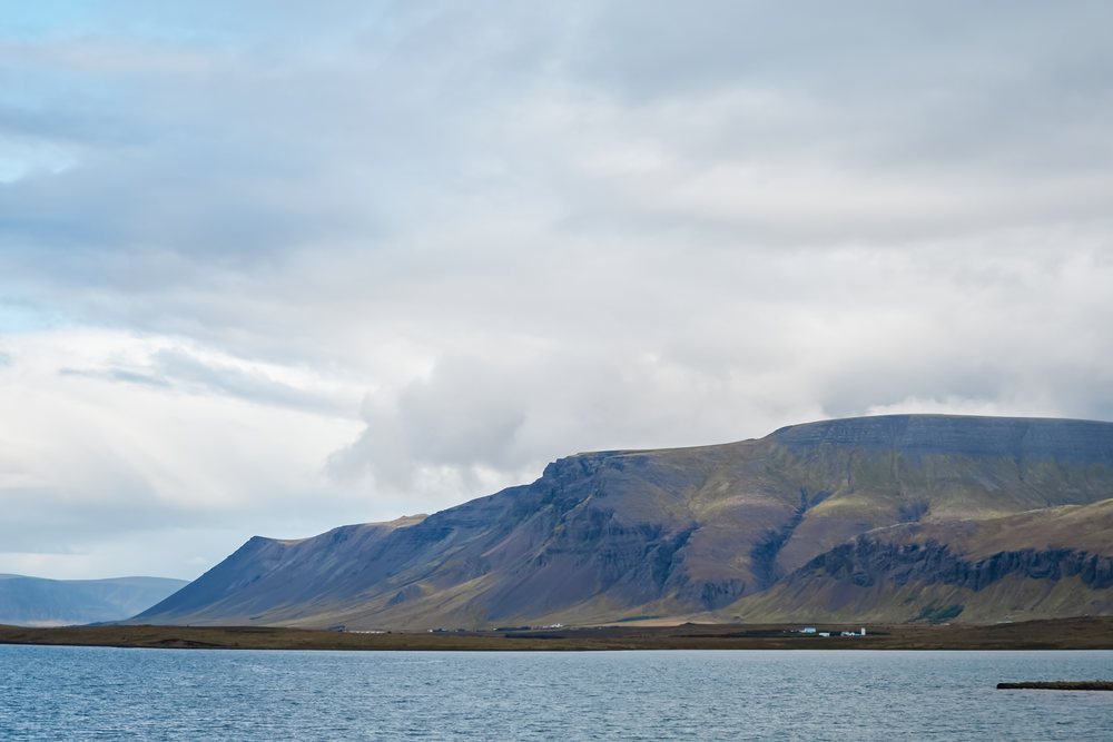 Mountain range overlooking a lake under a cloudy sky