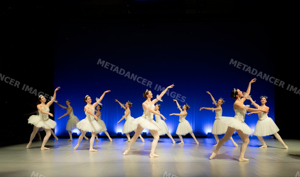 Ballet dancers performing a graceful group dance on stage