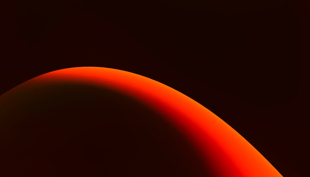 Red and orange gradient curved shape with shadow on black background.