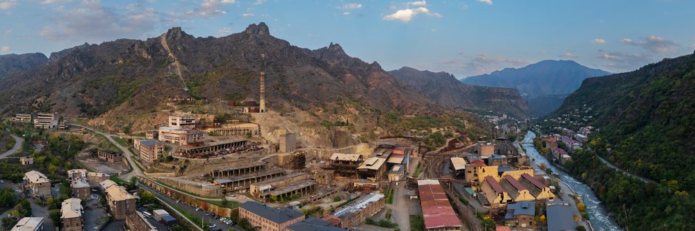 Historic copper mine ruins with chimney stack in a mountain valley beside a river, Alaverdi, Armenia.