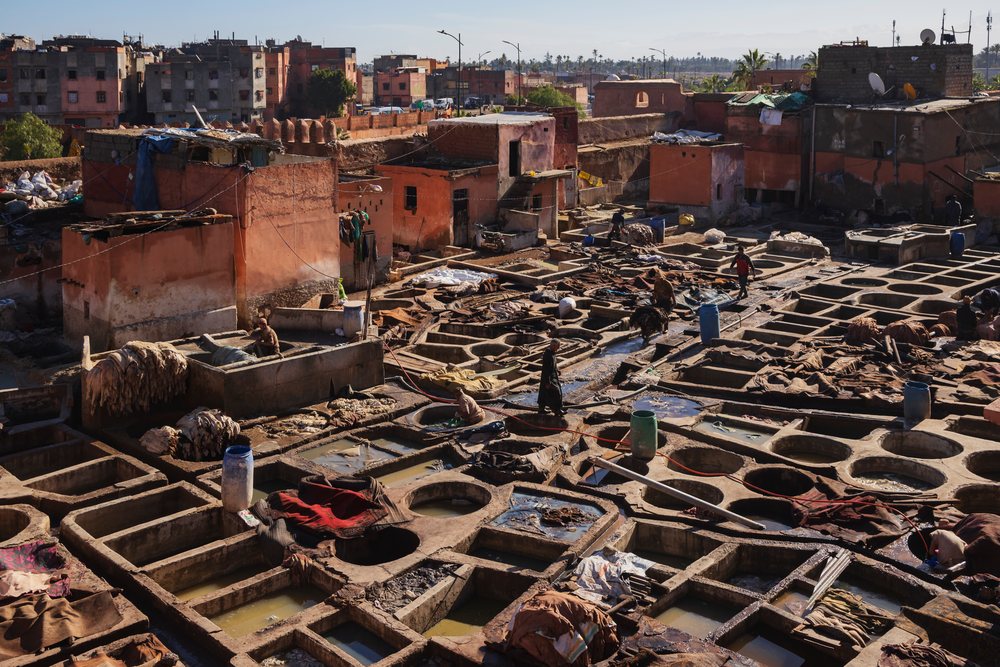 Outdoor tannery with artisans working in leather dyeing pits, Lifestyle, Landscape, Culture, Marrakech, Marrakesh-Safi Region, Morocco.